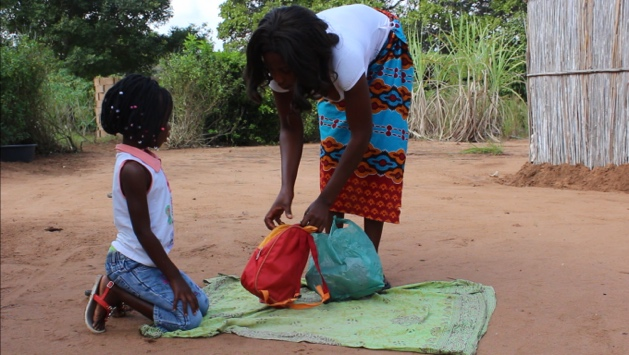 Dalfa being prepared by for school by her mother